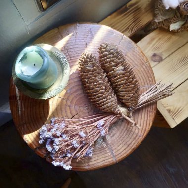 Tahta bir masadaki vazoda kurumuş çiçekler.