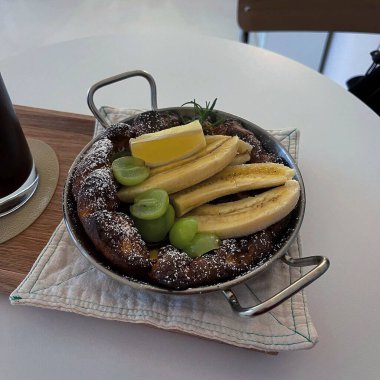 Bir fincan kahve, bir kek ve bir muzun dikey çekimi.