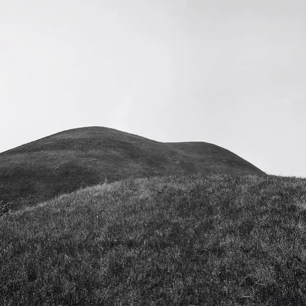 Beyaz gökyüzü ile güzel bir tepe manzarası
