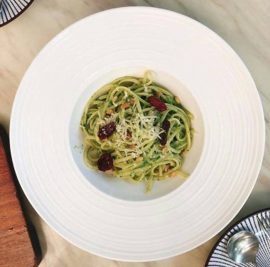 Masada beyaz tabakta peynir soslu spagetti ve makarna.