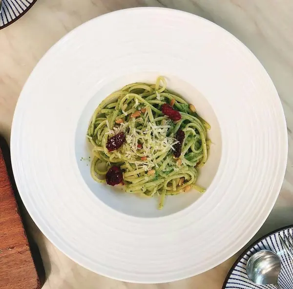 Masada beyaz tabakta peynir soslu spagetti ve makarna.