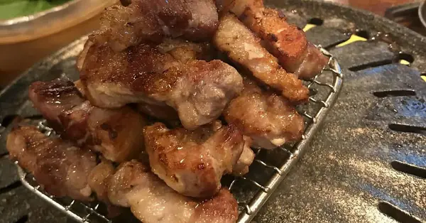 Ahşap ızgarada kızarmış tavuk kanadı.