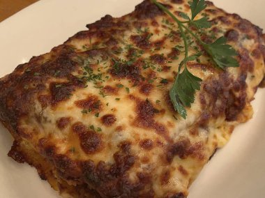 Beyaz bir tabakta nefis bir lazanya resmi.