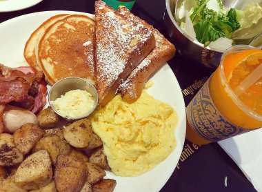 Tahta arka planda bir fincan çayla kahvaltı.