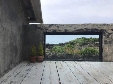 Penceresi ve denizi olan boş ahşap masa