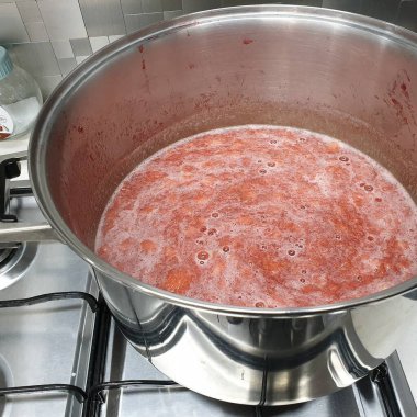 Kırmızı soslu bir kasenin dikey görüntüsü.