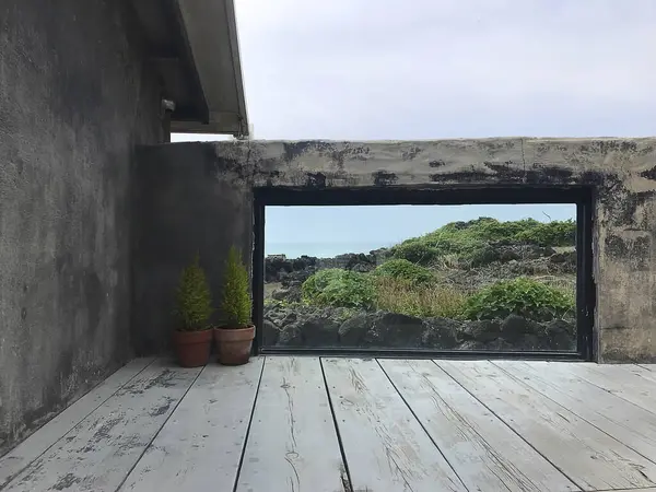 Penceresi ve denizi olan boş ahşap masa