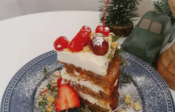 Meyveli lezzetli bir pastanın ve masanın üstünde bir fincan çayın yakın çekimi.