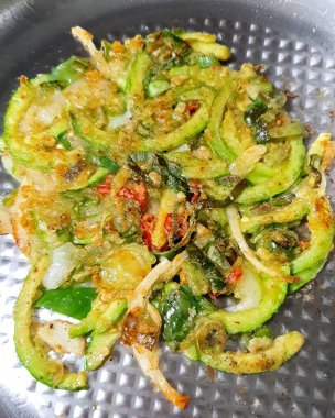 Kızarmış yeşil sebzeleri baharat ve sosla karıştırın.