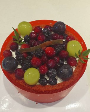 Bir kase taze meyve salatası, bir kaşık ve bir fincan süt.