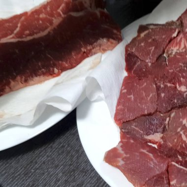 Baharatlı taze biftek ve beyaz tabakta otlar. en üstteki görünüm.