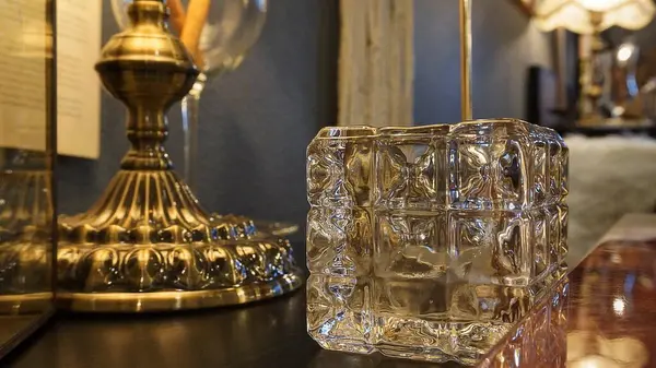 Cam vazo ve ahşap bir masanın üzerinde bir bardak su.