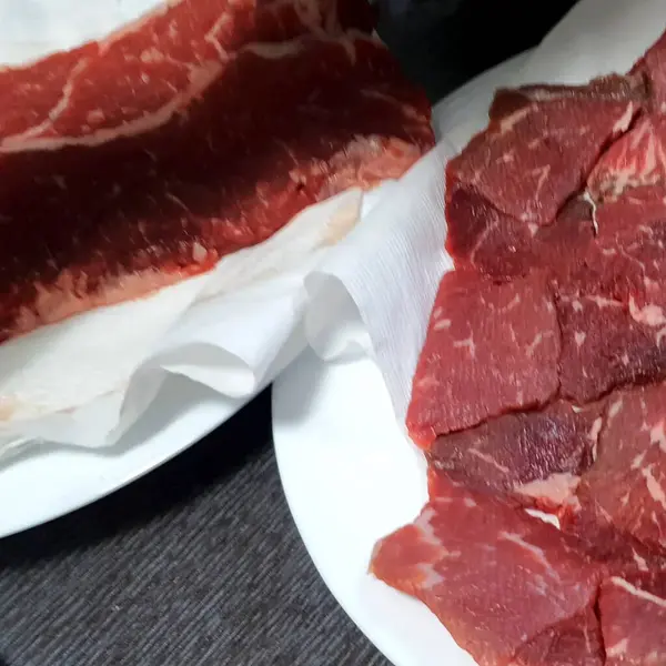 Baharatlı taze biftek ve beyaz tabakta otlar. en üstteki görünüm.