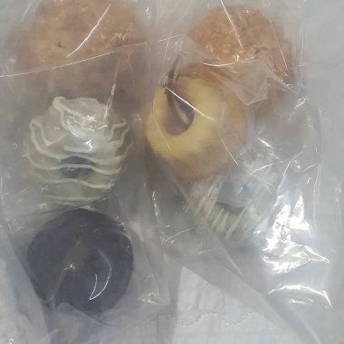 Lezzetli bir pastanın dikey çekimi ve kahverengi bir masada beyaz bir plastik torba.