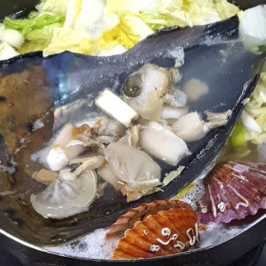 Tavada balıkla deniz ürünleri pişirmek.