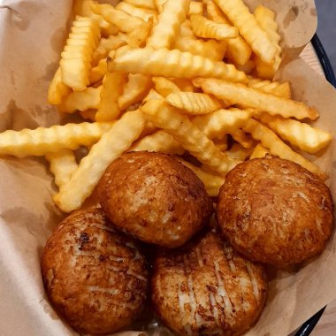 Kağıt üzerinde patates ve sebzeli kızarmış tavuk.