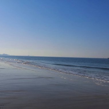 Mavi dalgaları ve dalgaları olan güzel sahil