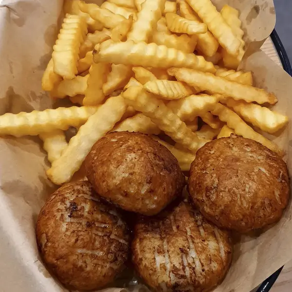 Kağıt üzerinde patates ve sebzeli kızarmış tavuk.