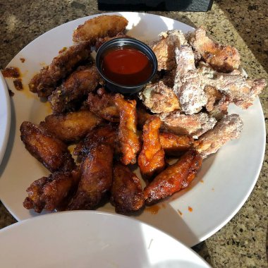 Yüksek açılı bir yakın çekim. Lezzetli bir kızarmış tavuk kanadı ve beyaz bir tabak.