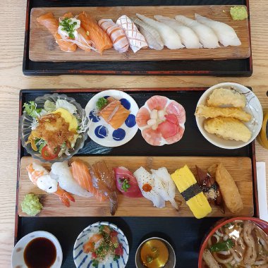 Değişik suşi çeşitleri ve ahşap masada yuvarlanmalar.