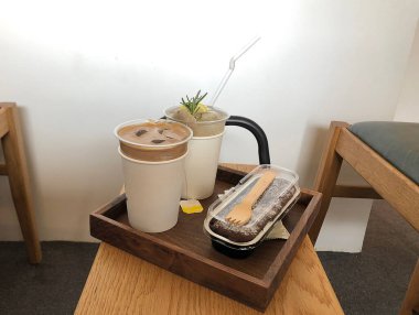 Kahve çekirdekli kahve fincanı ve tahta masada süt.