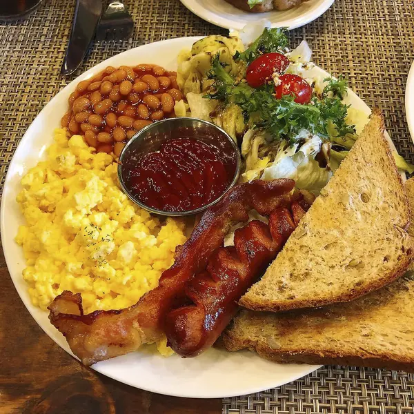 Yumurtalı kahvaltı, pastırma, tost, fasulye ve salata.