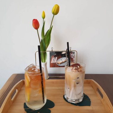 Süt ve buzlu buzlu kahve, ahşap bir arka planda.