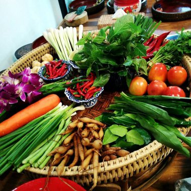 Tahta bir masada sepetteki taze sebzeler.