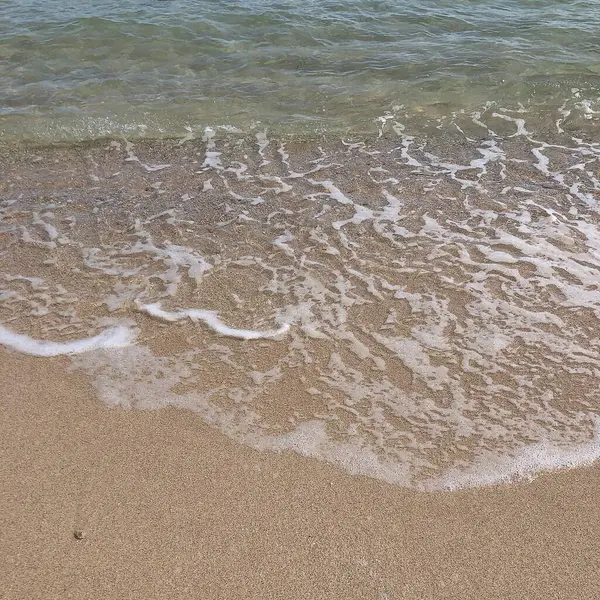 Okyanusun arka planında güzel deniz suyu ve kum.