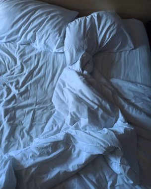 Dağınık çarşaflı beyaz yatak