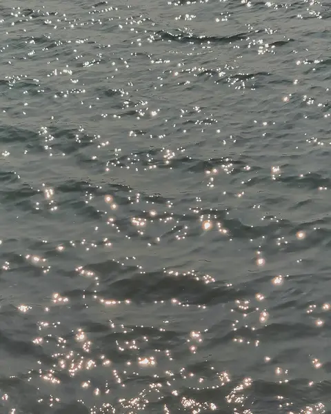 Siyah zemin üzerinde deniz dalgaları. Gün batımında deniz dalgaları