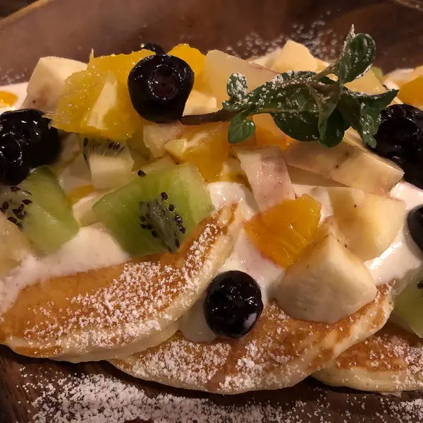 Taze ev yapımı krepleri bir tabakta böğürtlen, bal ve nane yapraklarıyla kapatın..