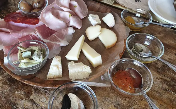 Tahta masadaki farklı peynir çeşitleri.