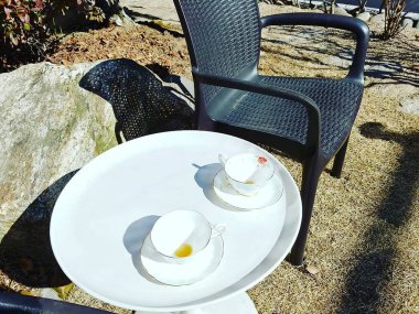 Masanın üzerinde siyah çay olan beyaz bardak.