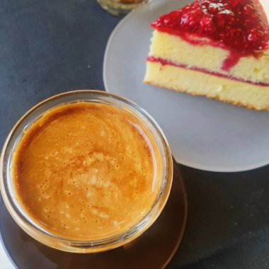 Tahta arka planda bir fincan kahve ve kek.