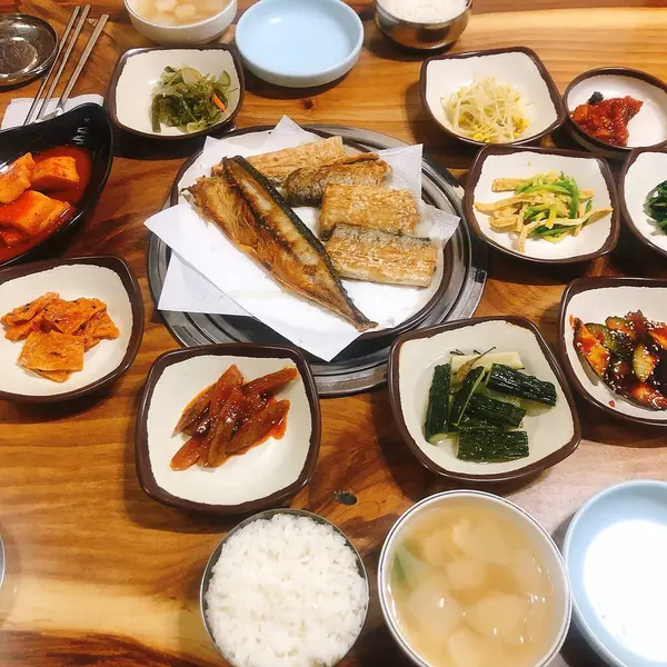 Masada pirinç ve et bulunan çeşitli Kore yemekleri.