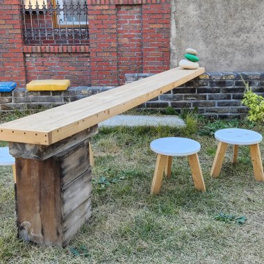 Bahçesinde sandalyeler ve masalar olan ahşap masa.