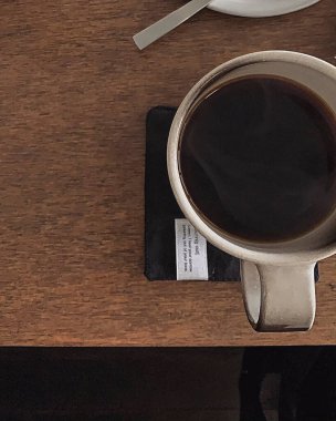 Kahve fincanı ve kahve masanın üstünde.