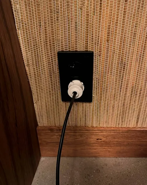 Beyaz duvarda fişi olan elektrik düğmesi.