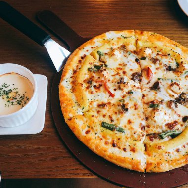 Ahşap masa üzerinde peynirli pizza