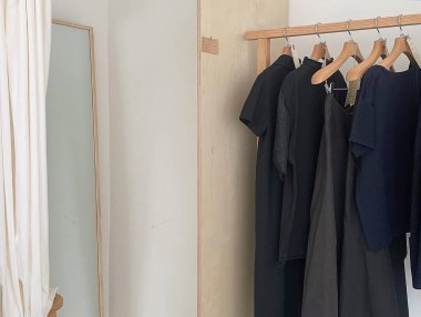 Elbiseleri askıda asılı bir elbise dolabı.