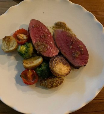 Soslu ve sebzeli bir bifteğin yüksek açılı çekimi.