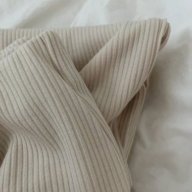 yumuşak ve beyaz kumaş yatağın üzerinde.