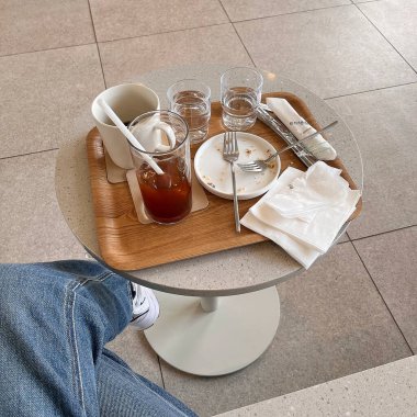 Kahve fincanı ve çay ahşap bir masada.