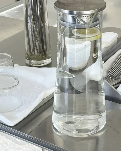 Cam şişe ve su mutfak masasında.