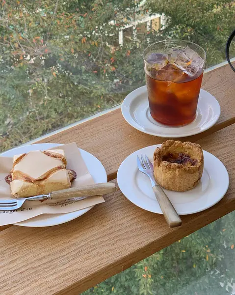 Bir fincan çay, bir kek ve beyaz bir tabak, bir kaşık kahve ve bir bardak çay.