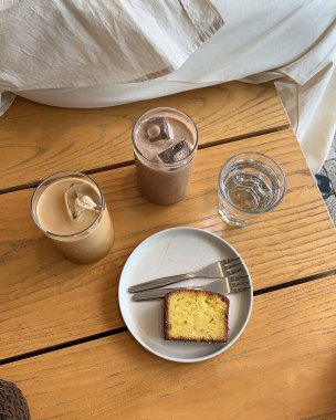 Bir bardak sütle nefis bir kahvaltı ve ahşap bir masada beyaz bir fincan kahve.