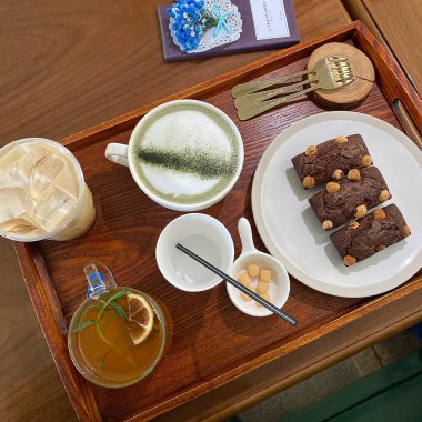 kahve fincanı, çay ve kurabiyeler masada.