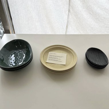 Beyaz arka planda bir bardak şaraplı siyah tabak.