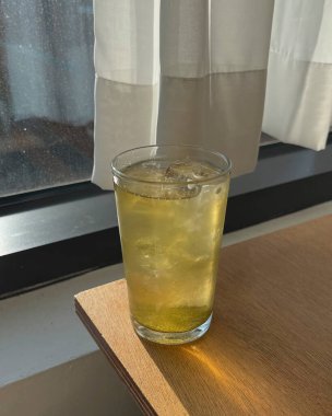 Pencere kenarında limon olan bir bardak taze buz.